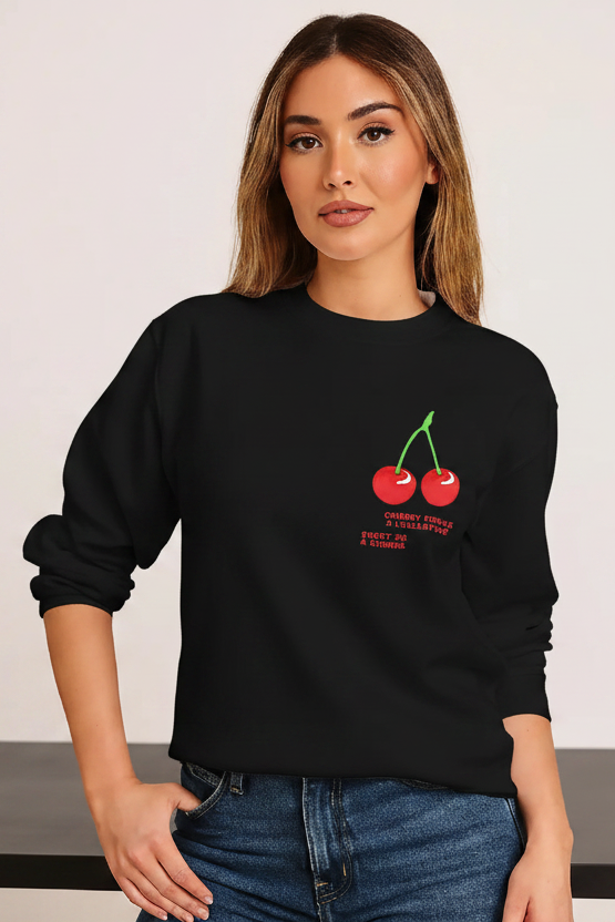 Woman wearing a black sweatshirt with a cherry design on a white background